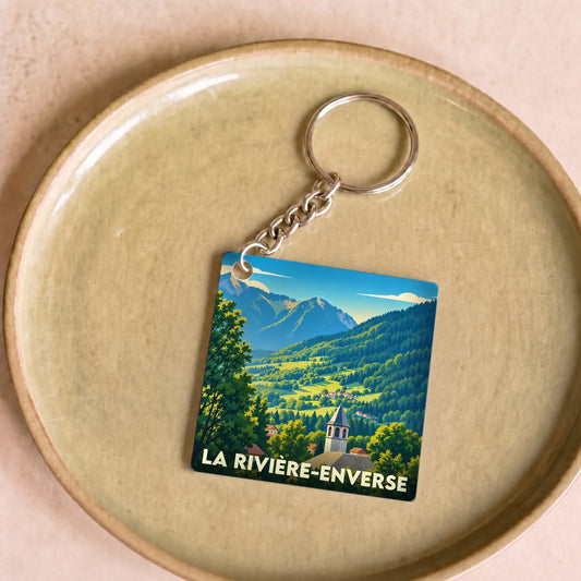Porte-clés souvenir de la ville de La Rivière-Enverse avec une illustration stylisée de paysages montagneux.