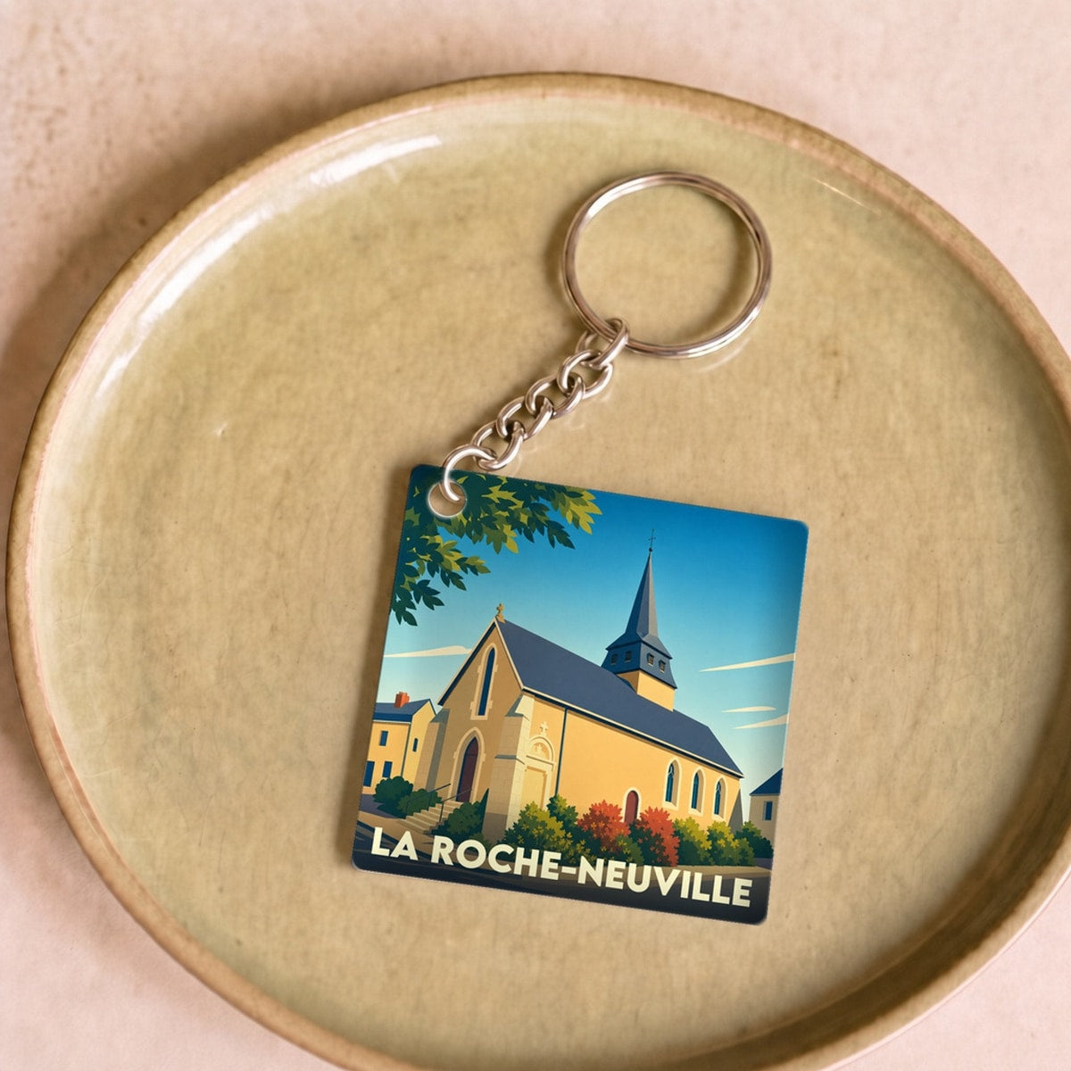 Porte-clés souvenir de la ville de La Roche-Neuville avec une illustration stylisée d'une église.