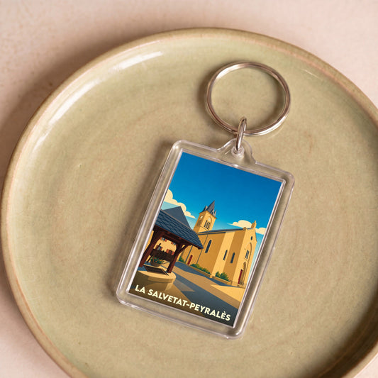 Porte-clés souvenir de la ville de La Salvetat-Peyralès avec une illustration stylisée.
