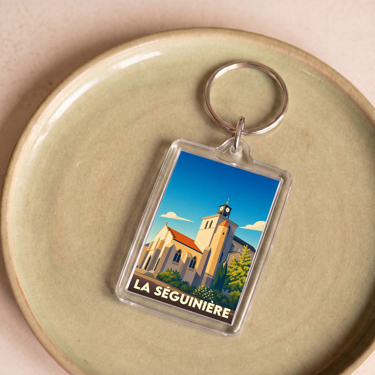 Porte-clés souvenir de la ville de La Séguinière avec une illustration stylisée de son église.