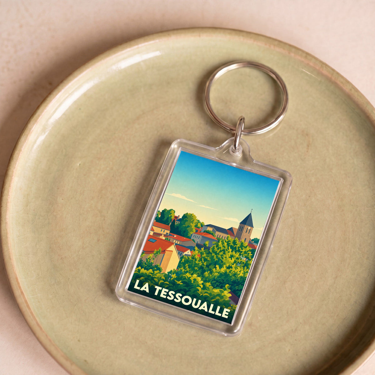 Porte-clés souvenir de la ville de La Tessoualle avec une illustration stylisée.