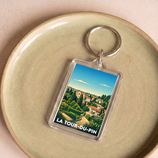 Porte-clés souvenir de la ville de La Tour-du-Pin avec une illustration stylisée de ses paysages.