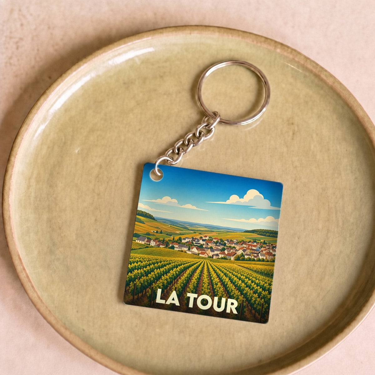 Porte-clés souvenir de la ville de La Tour avec une illustration stylisée de vignobles.
