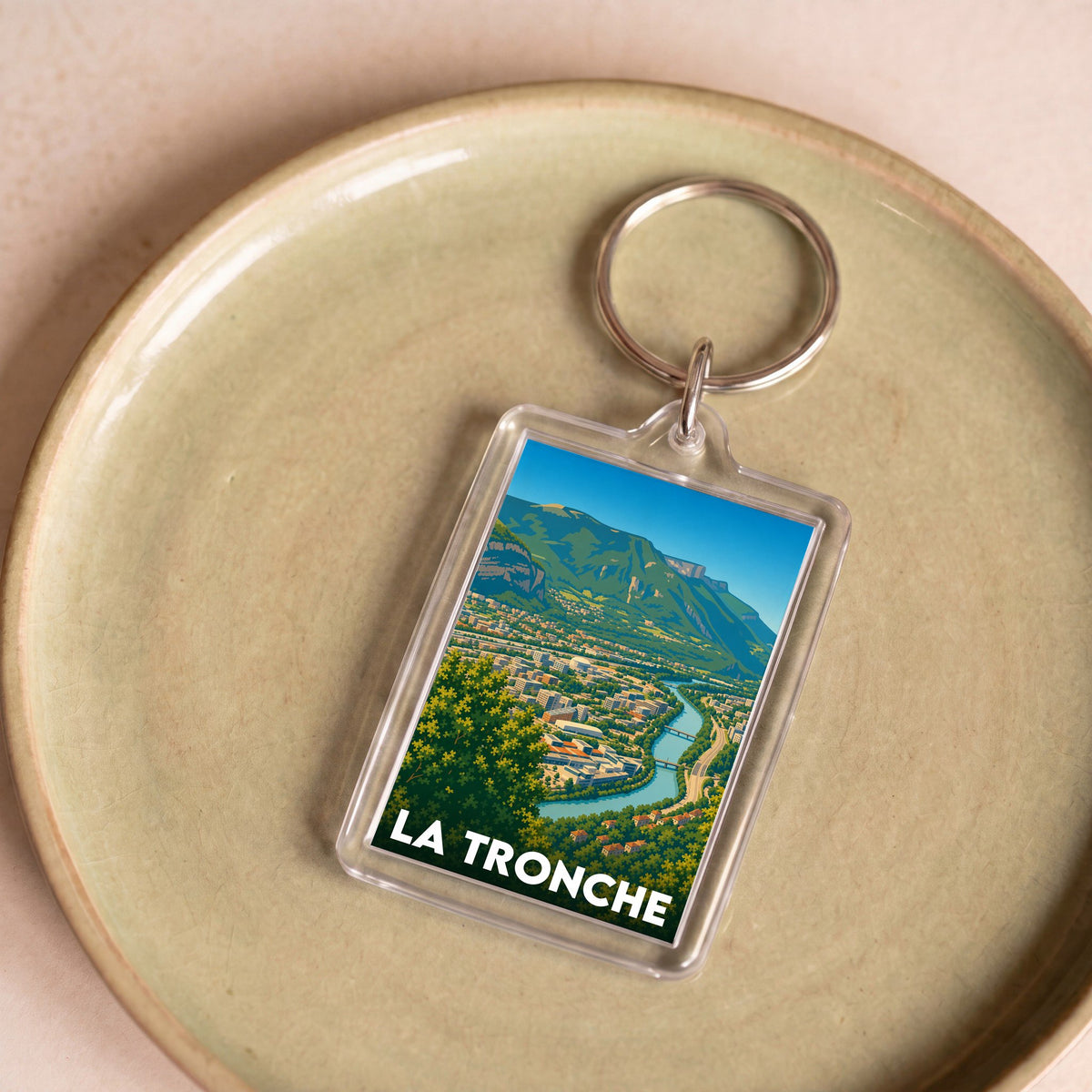Porte-clés souvenir de la ville de La Tronche avec une illustration stylisée d'un paysage montagneux.
