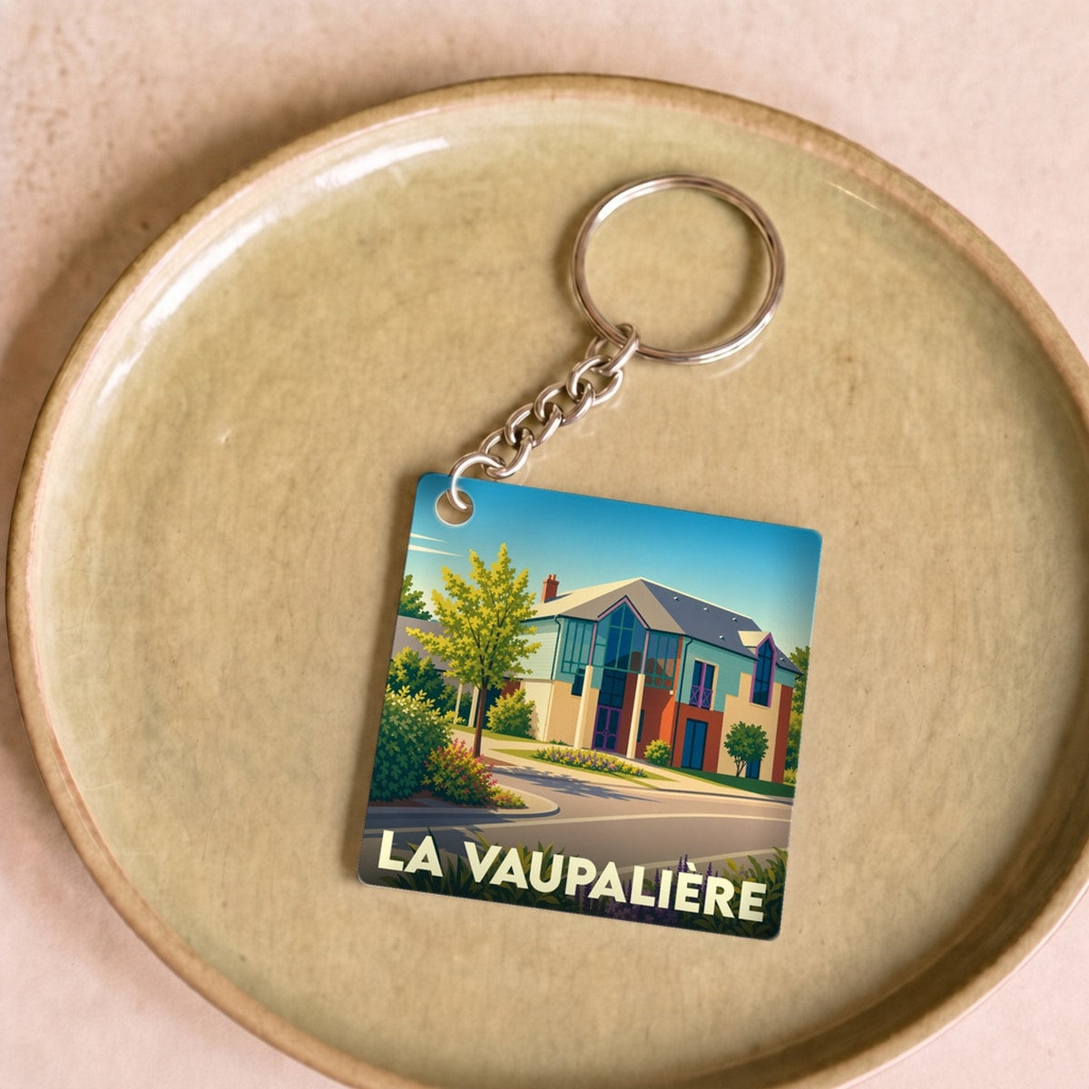 Porte-clés souvenir de la ville de La Vaupalière avec une illustration stylisée.