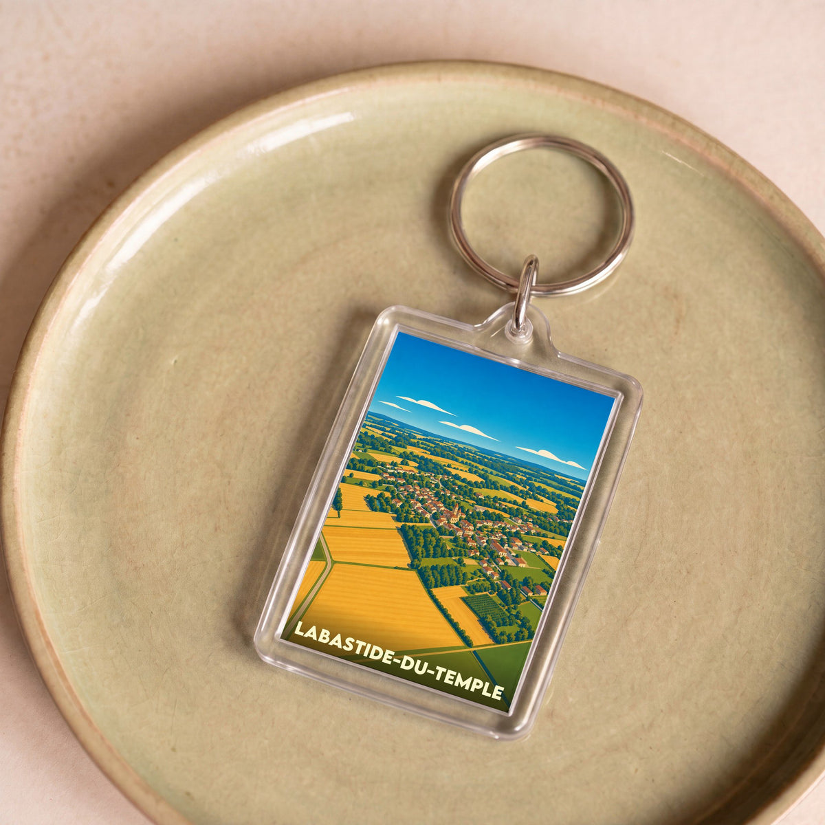 Porte-clés souvenir de la ville de Labastide-du-Temple avec une illustration aérienne et stylisée de ses paysages.