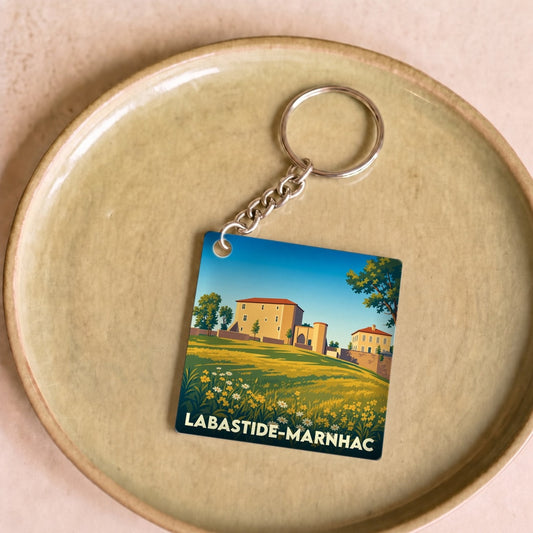 Porte-clés souvenir de la ville de Labastide-Marnhac avec une illustration stylisée de son paysage.