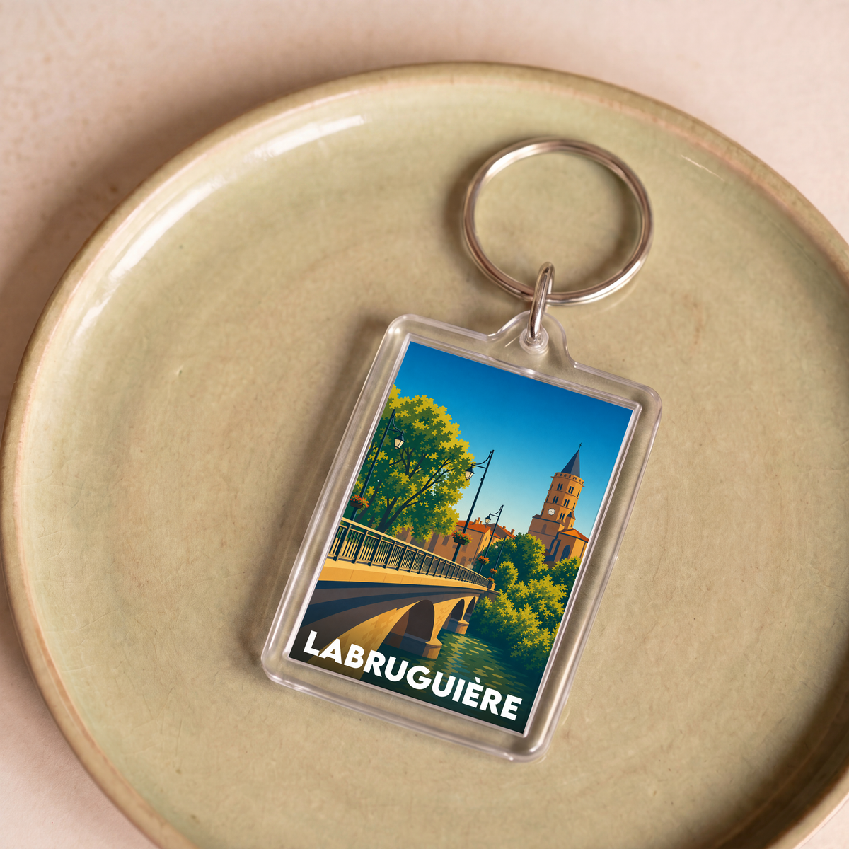Porte-clés souvenir de la ville de Labruguière avec une illustration stylisée d'un pont et d'une église.