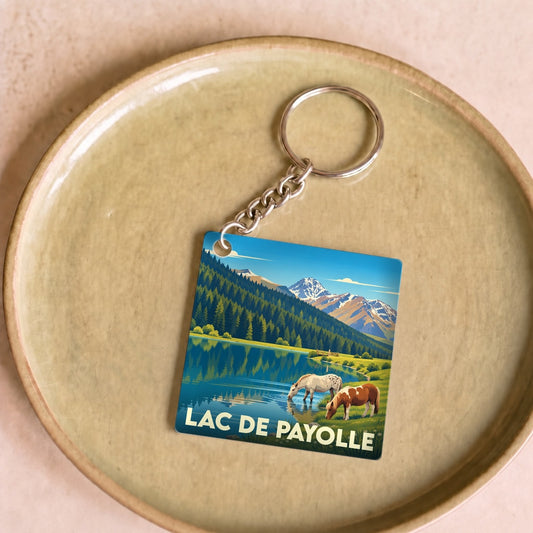 Porte-clés souvenir de Lac de Payolle avec une illustration stylisée de chevaux au bord du lac.