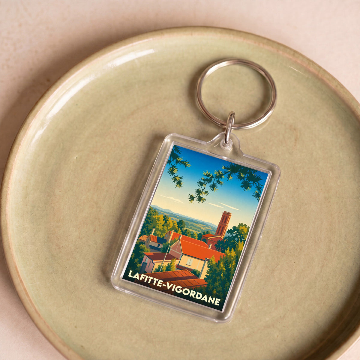 Porte-clés souvenir de la ville de Lafitte-Vigordane avec une illustration stylisée.