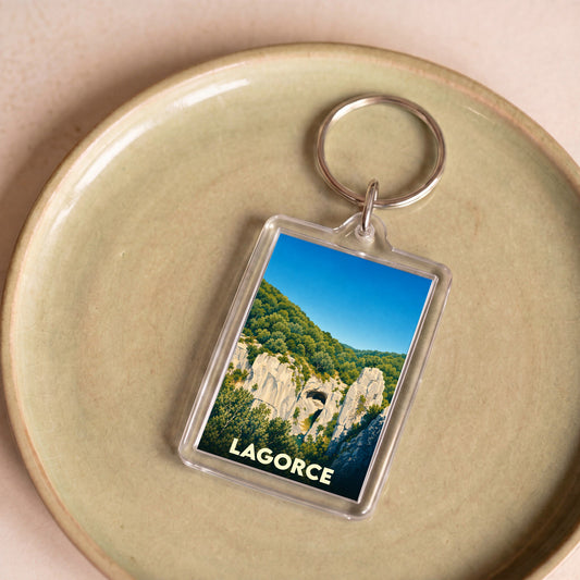 Porte-clés souvenir de la ville de Lagorce avec une illustration stylisée d'un paysage rocheux.