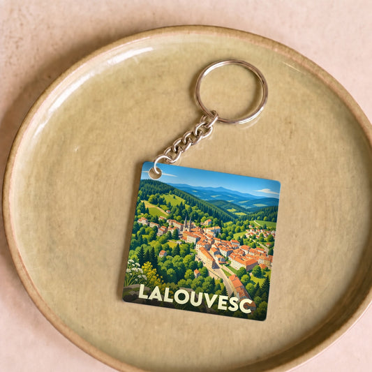 Porte-clés souvenir de la ville de Lalouvesc avec une illustration stylisée de son paysage montagneux.