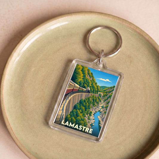 Porte-clés souvenir de la ville de Lamastre avec une illustration stylisée d'un train serpentant dans les gorges.