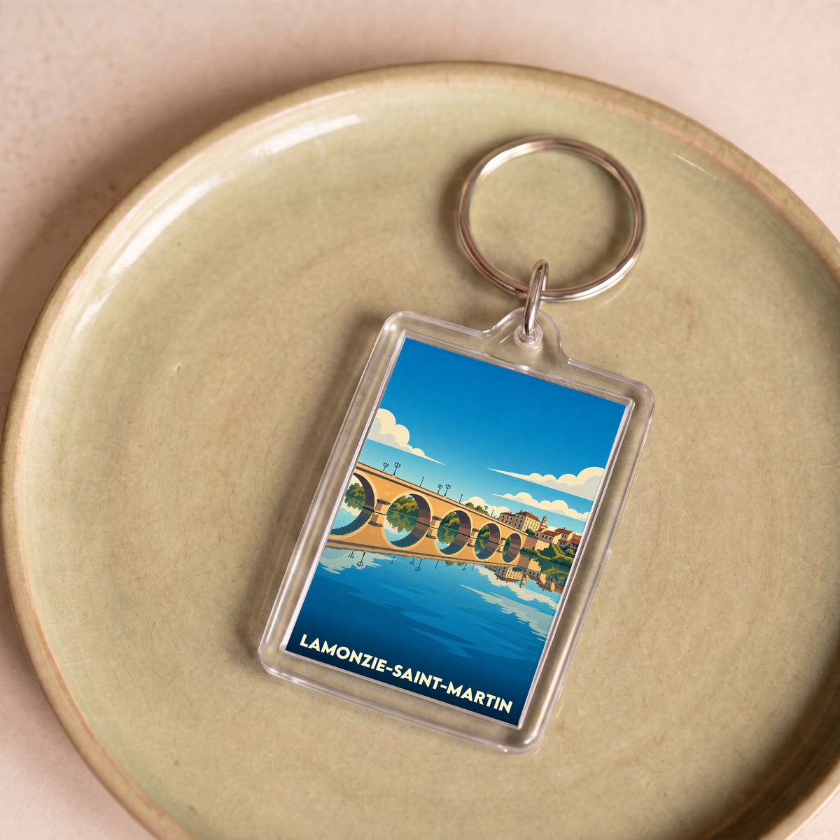 Porte-clés souvenir de la ville de Lamonzie-Saint-Martin avec une illustration stylisée d'un pont.