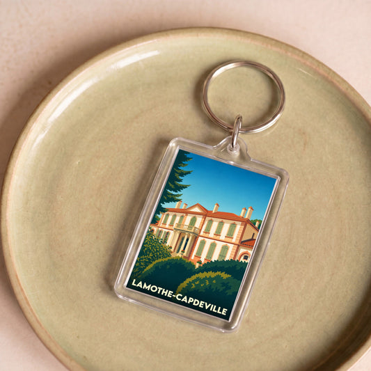 Porte-clés souvenir de la ville de Lamothe-Capdeville avec une illustration stylisée.