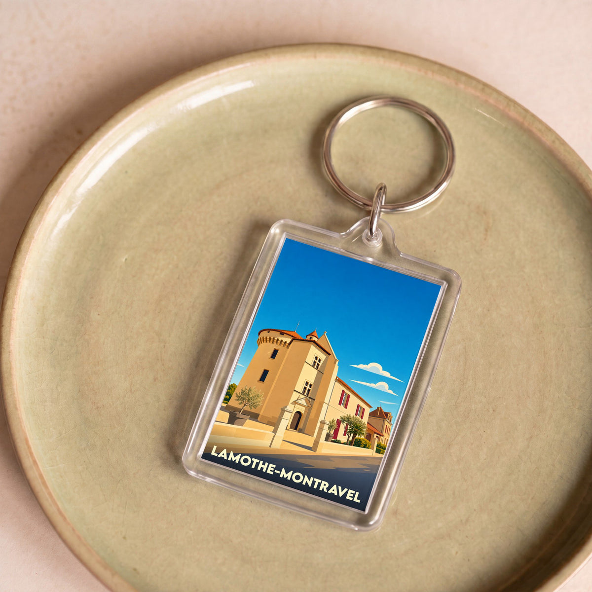 Porte-clés souvenir de la ville de Lamothe-Montravel avec une illustration stylisée.
