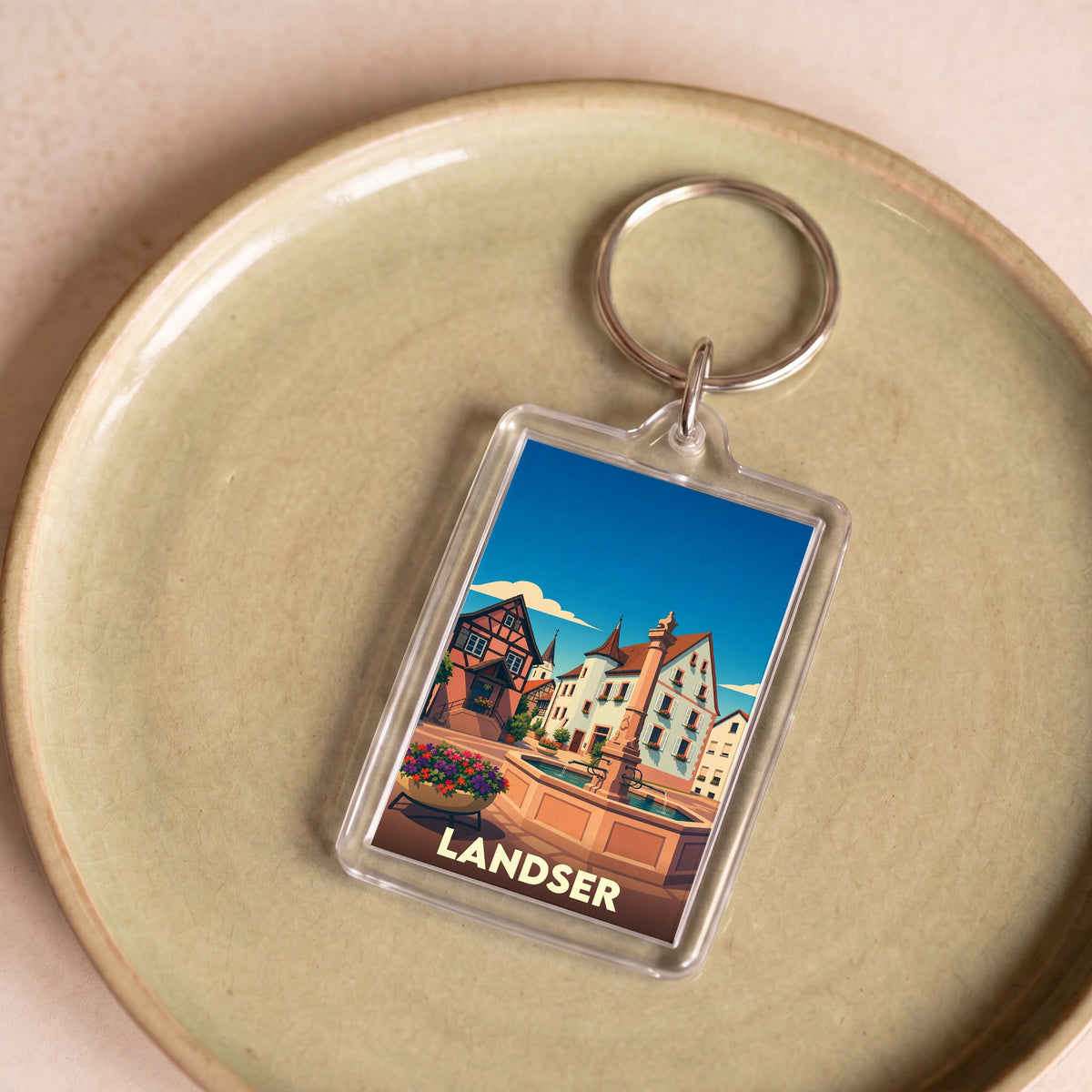 Porte-clés souvenir de la ville de Landser avec une illustration stylisée.