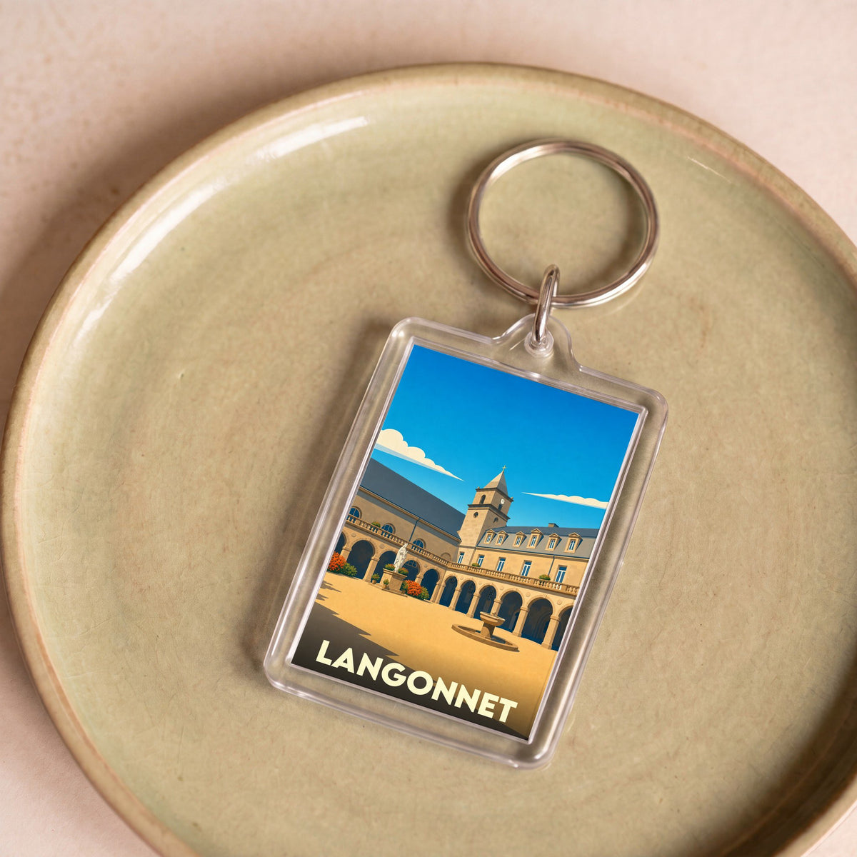 Porte-clés souvenir de la ville de Langonnet avec une illustration stylisée de son patrimoine.