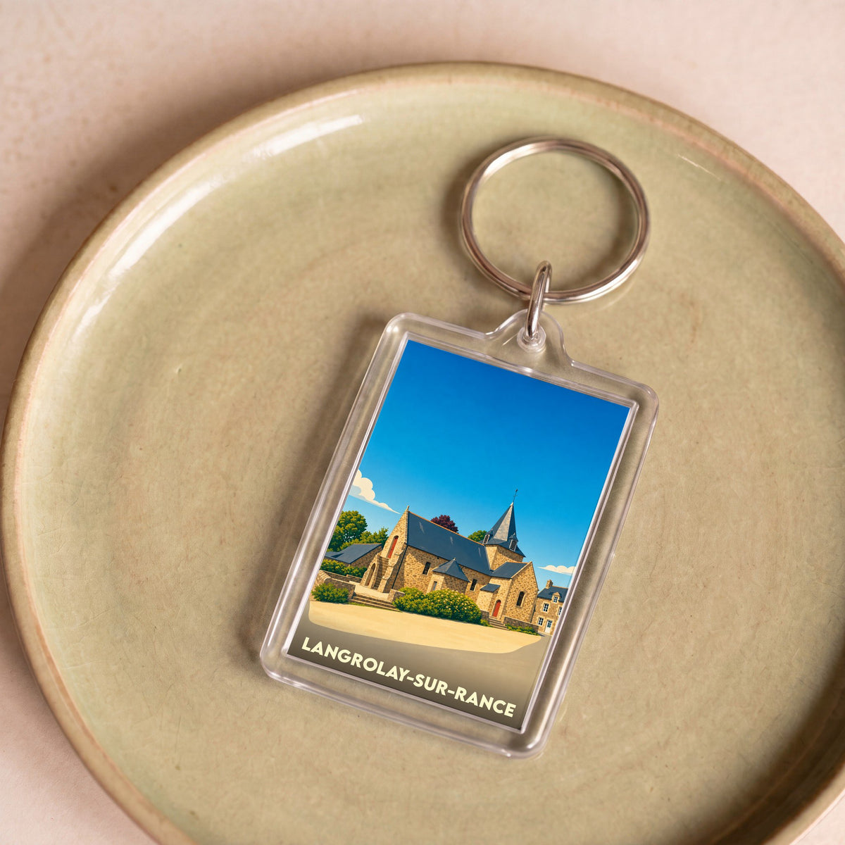 Porte-clés souvenir de la ville de Langrolay-sur-Rance avec une illustration stylisée de son église.
