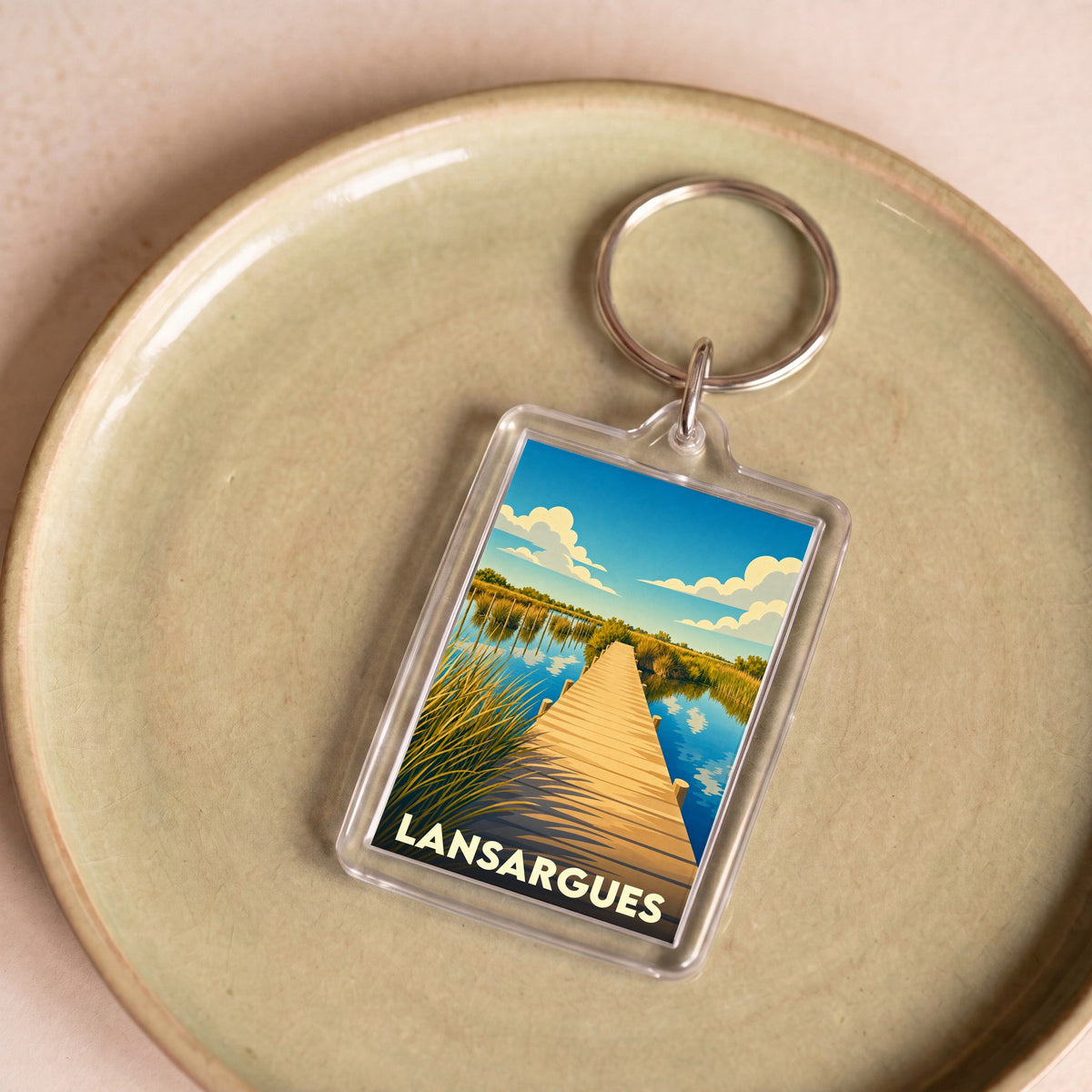 Porte-clés souvenir de la ville de Lansargues avec une illustration stylisée d'un ponton en bois.