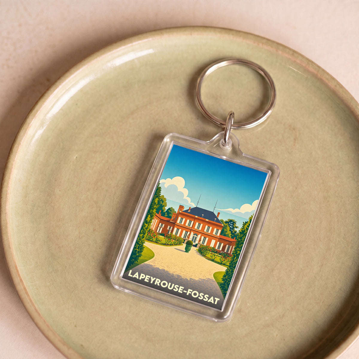 Porte-clés souvenir de la ville de Lapeyrouse-Fossat avec une illustration stylisée d'un château.