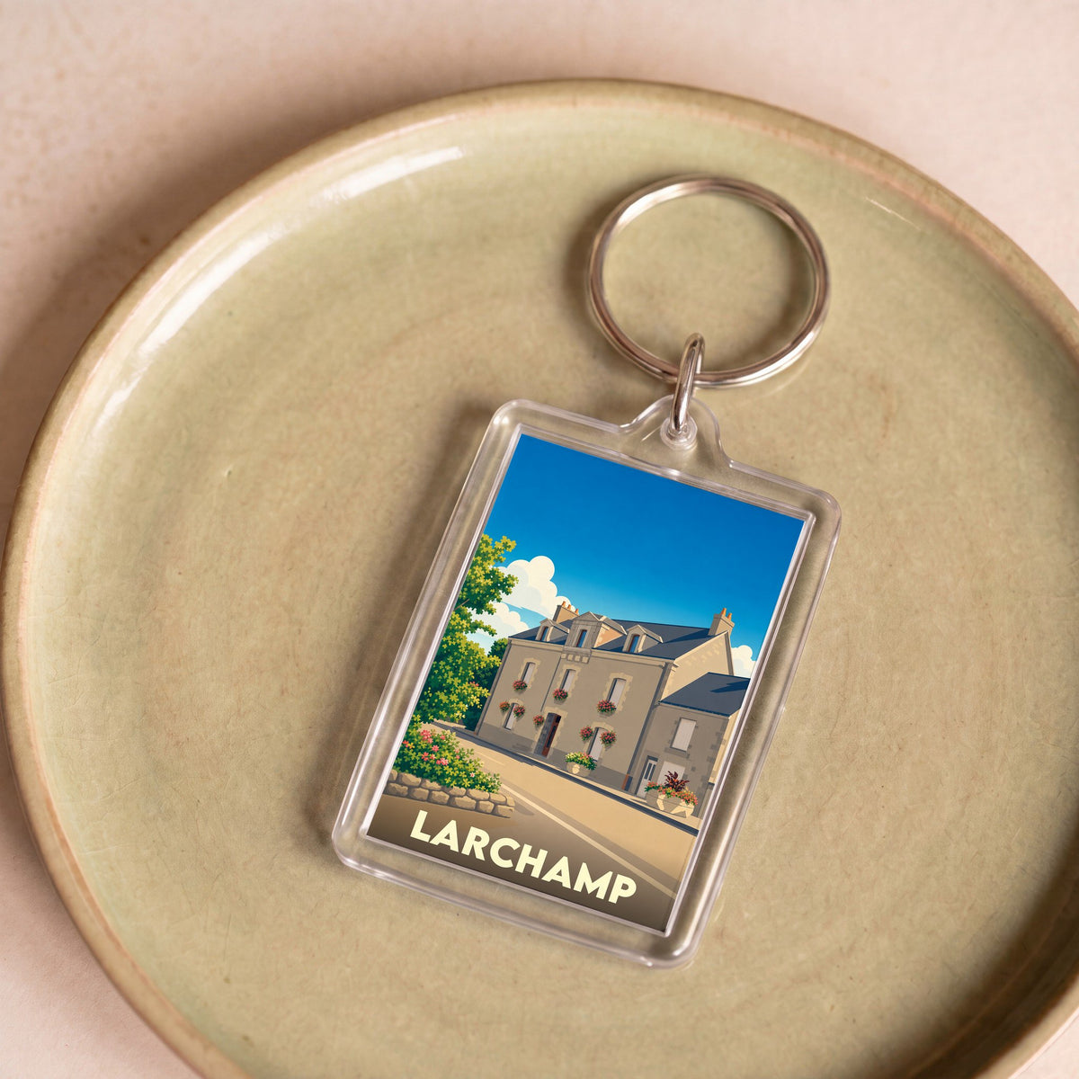 Porte-clés souvenir de la ville de Larchamp avec une illustration stylisée.