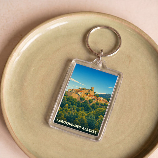 Porte-clés souvenir de la ville de Laroque-des-Albères avec une illustration stylisée.