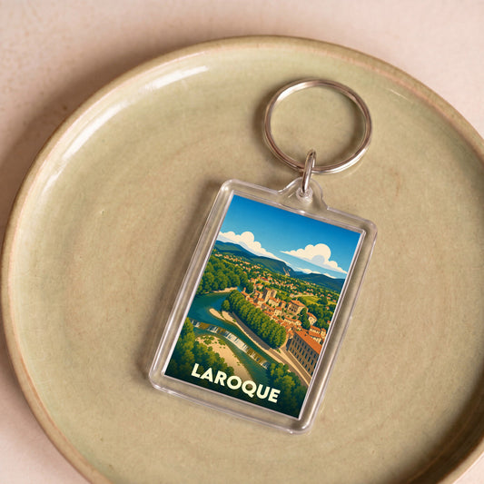 Porte-clés souvenir de la ville de Laroque avec une illustration stylisée.