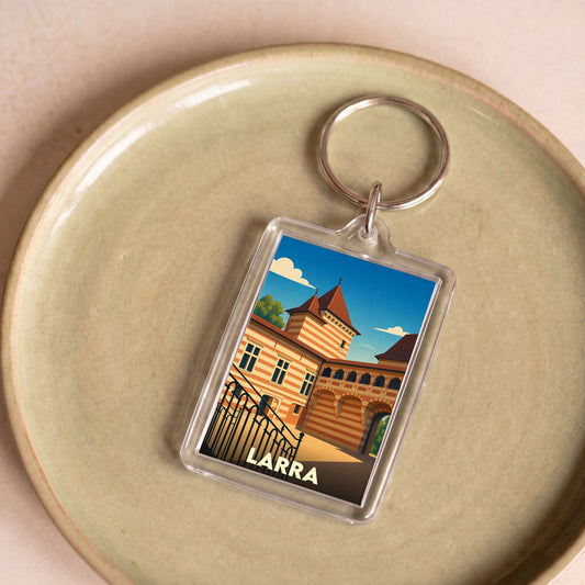 Porte-clés souvenir de la ville de Larra avec une illustration stylisée de son château.