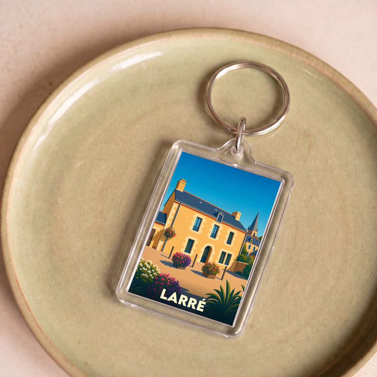 Porte-clés souvenir de la ville de Larré avec une illustration stylisée d'un bâtiment traditionnel.