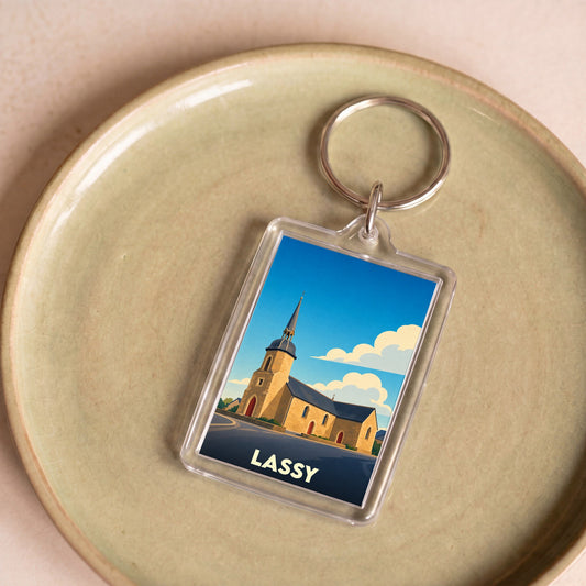 Porte-clés souvenir de la ville de Lassy avec une illustration stylisée de son église.