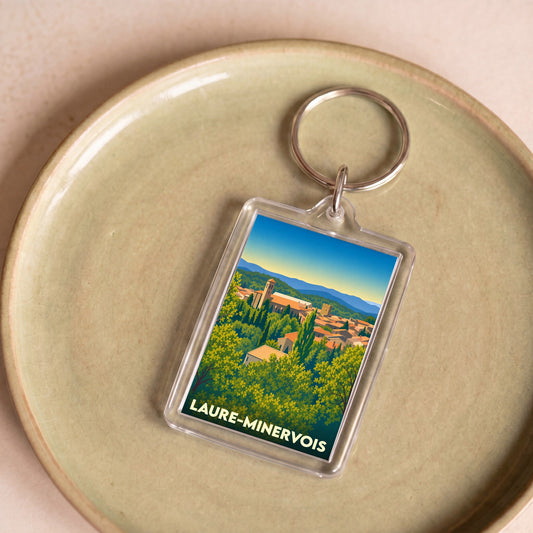 Porte-clés souvenir de la ville de Laure-Minervois avec une illustration stylisée.