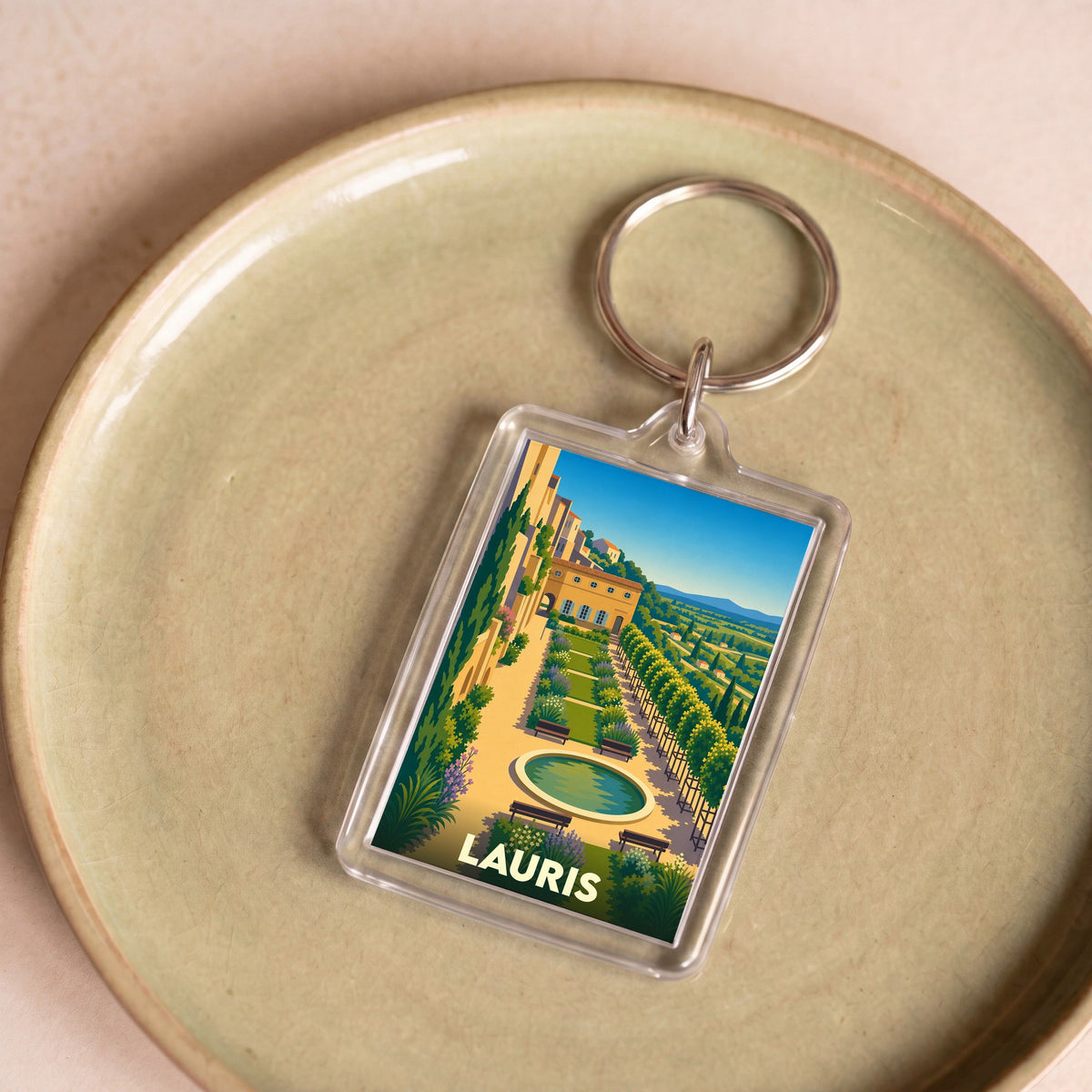 Porte-clés souvenir de la ville de Lauris avec une illustration stylisée de ses jardins en terrasses.