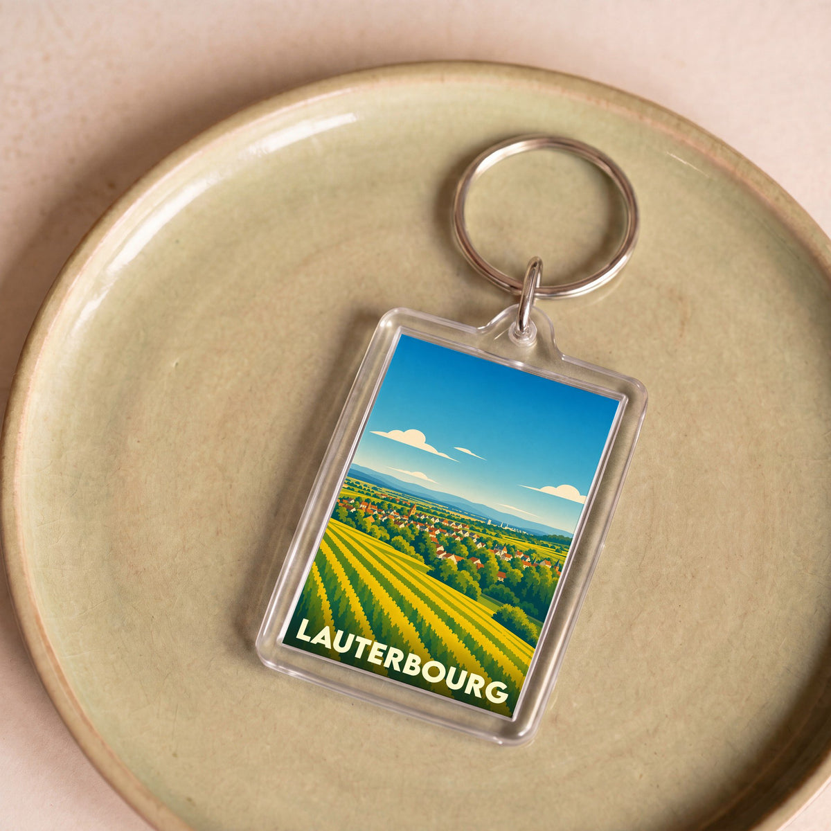 Porte-clés souvenir de la ville de Lauterbourg avec une illustration stylisée de paysages alsaciens.