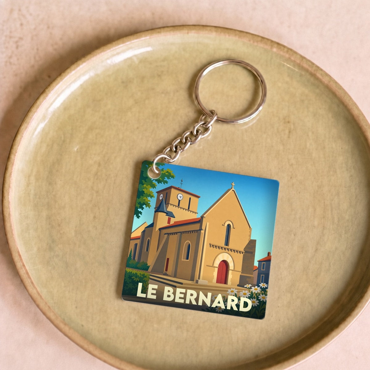 Porte-clés souvenir de la ville du Bernard avec une illustration stylisée de son église.