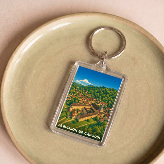 Porte-clés souvenir de la ville de Le Buisson-de-Cadouin avec une illustration stylisée de son abbaye.