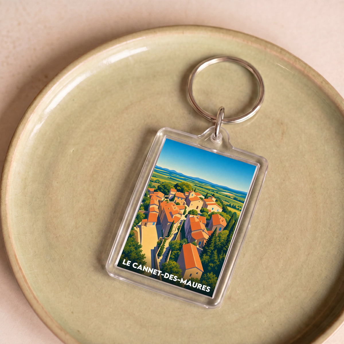 Porte-clés souvenir de la ville de Le Cannet-des-Maures avec une illustration stylisée.
