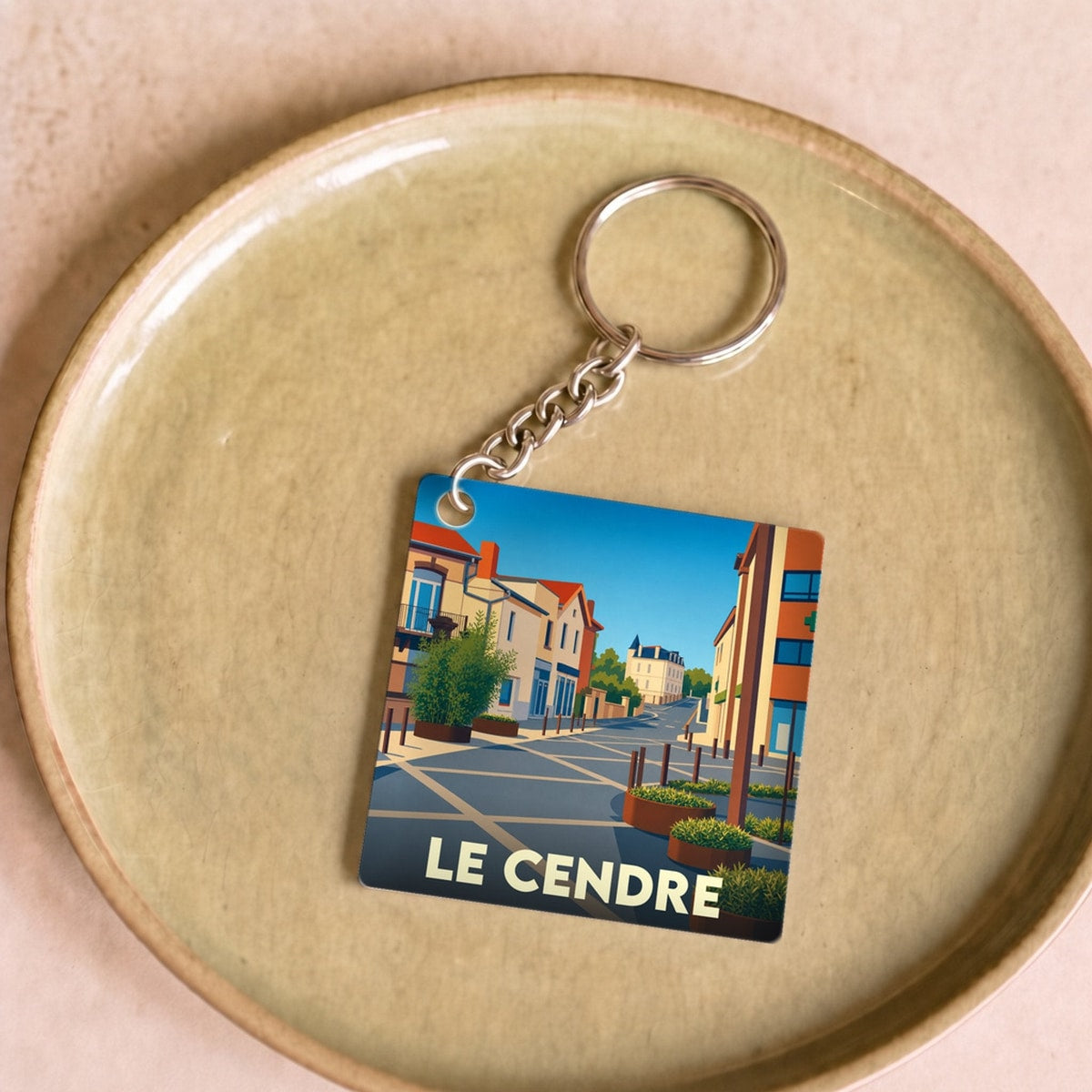 Porte-clés souvenir de la ville du Cendre avec une illustration stylisée.