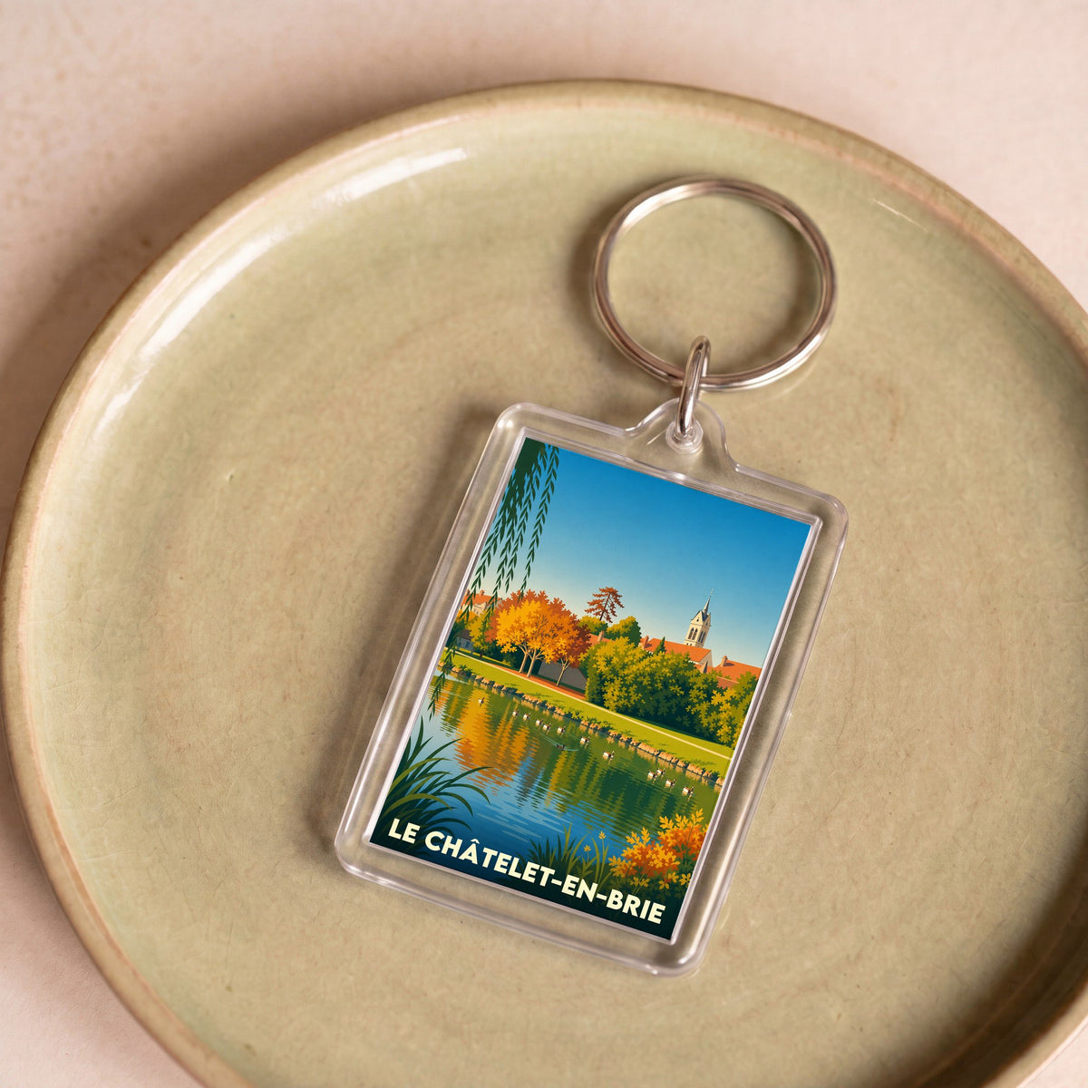 Porte-clés souvenir de la ville du Châtelet-en-Brie avec une illustration stylisée de ses paysages.