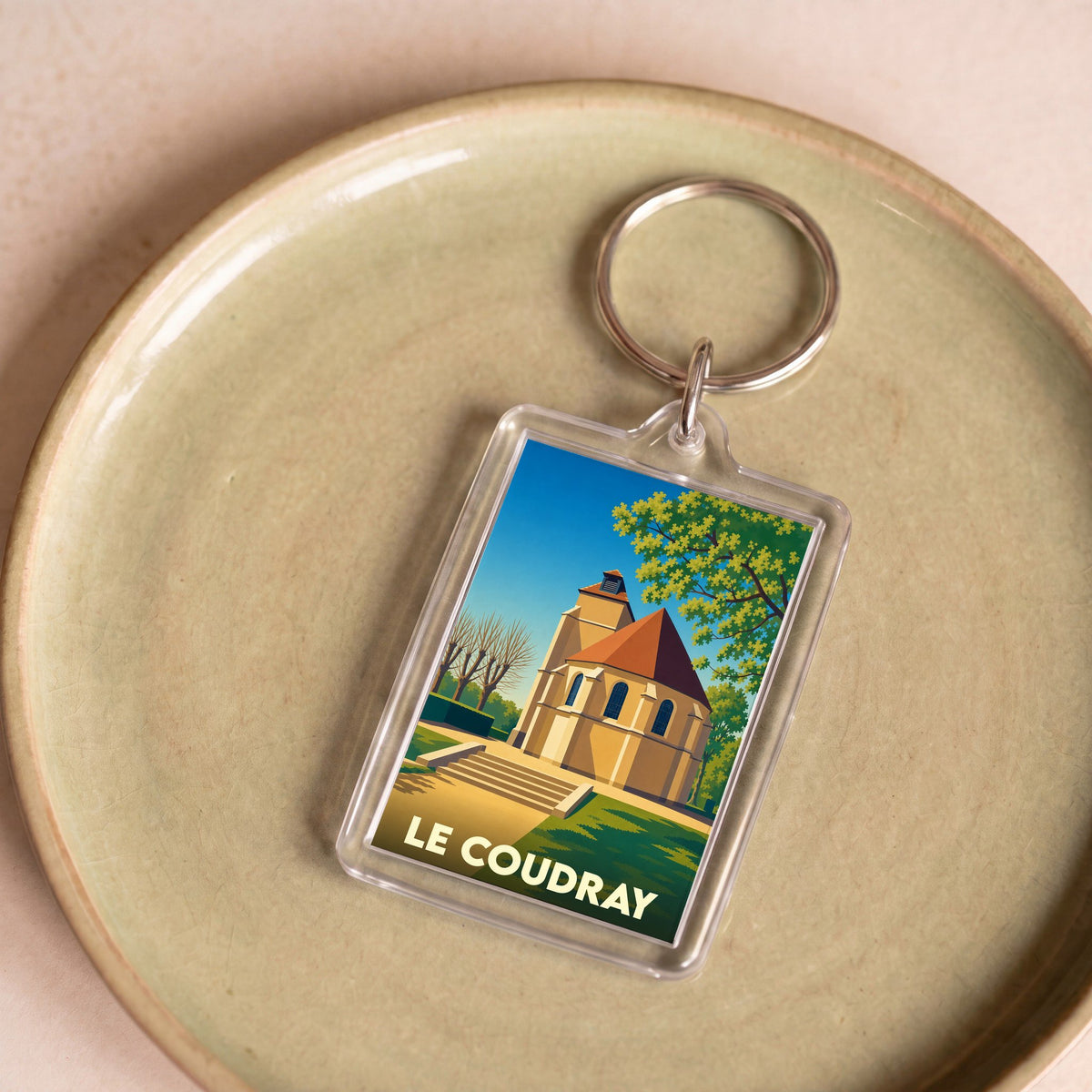 Porte-clés souvenir de la ville de Le Coudray avec une illustration stylisée de son église.