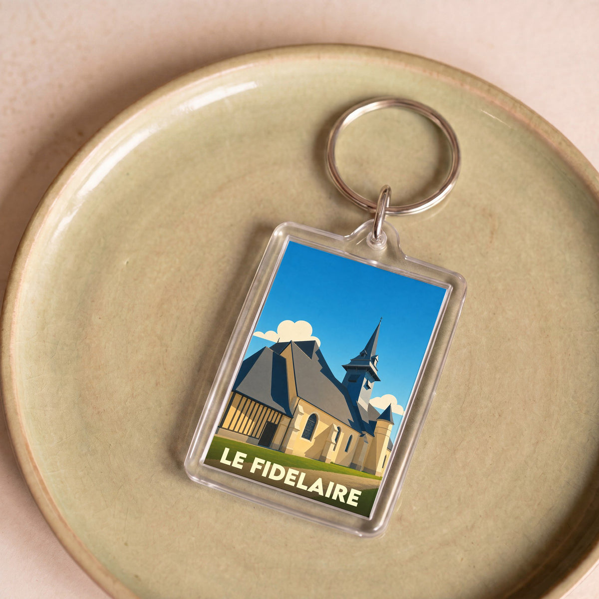 Porte-clés souvenir de la ville de Le Fidelaire avec une illustration stylisée de son église.