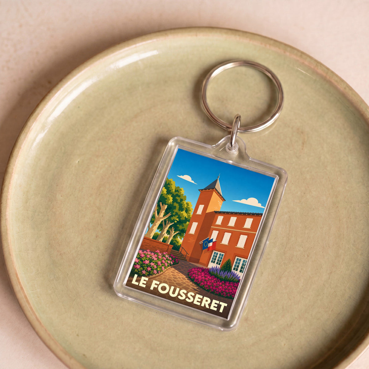 Porte-clés souvenir de la ville de Le Fousseret avec une illustration stylisée de sa mairie.