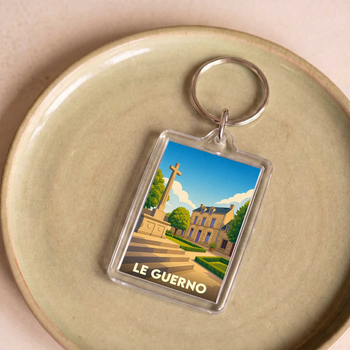 Porte-clés souvenir de la ville du Guerno avec une illustration stylisée.