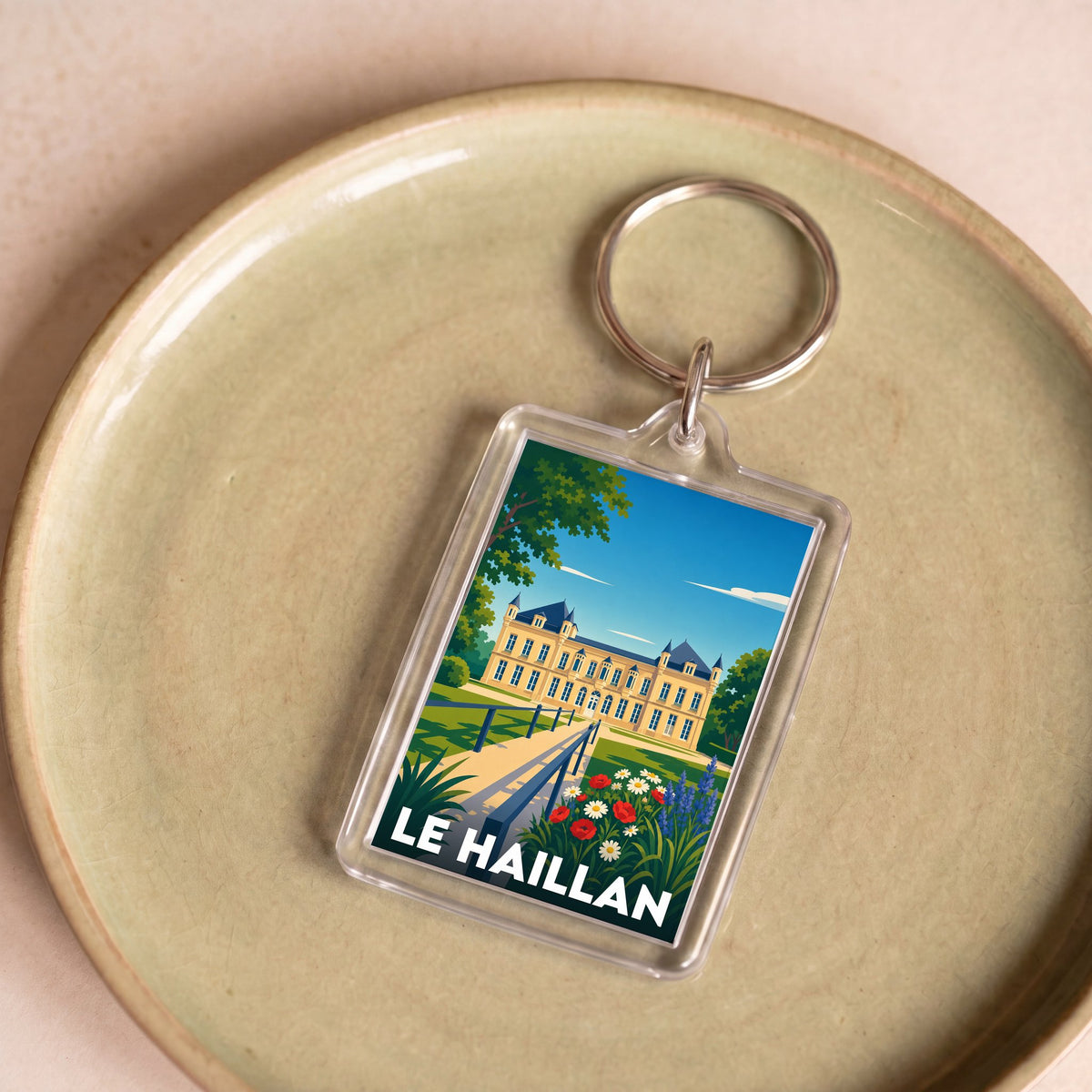 Porte-clés souvenir de la ville de Le Haillan avec une illustration stylisée du château.