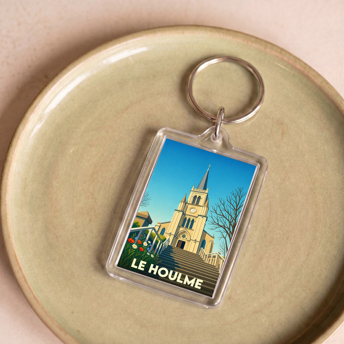 Porte-clés souvenir de la ville de Le Houlme avec une illustration stylisée de son église.