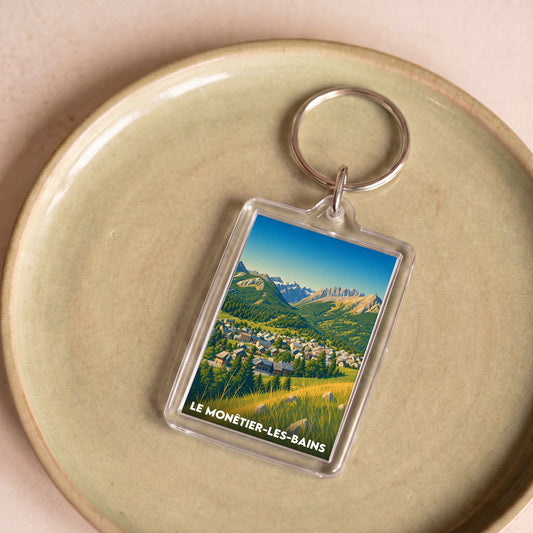 Porte-clés souvenir de la ville de Le Monêtier-les-Bains avec une illustration stylisée.