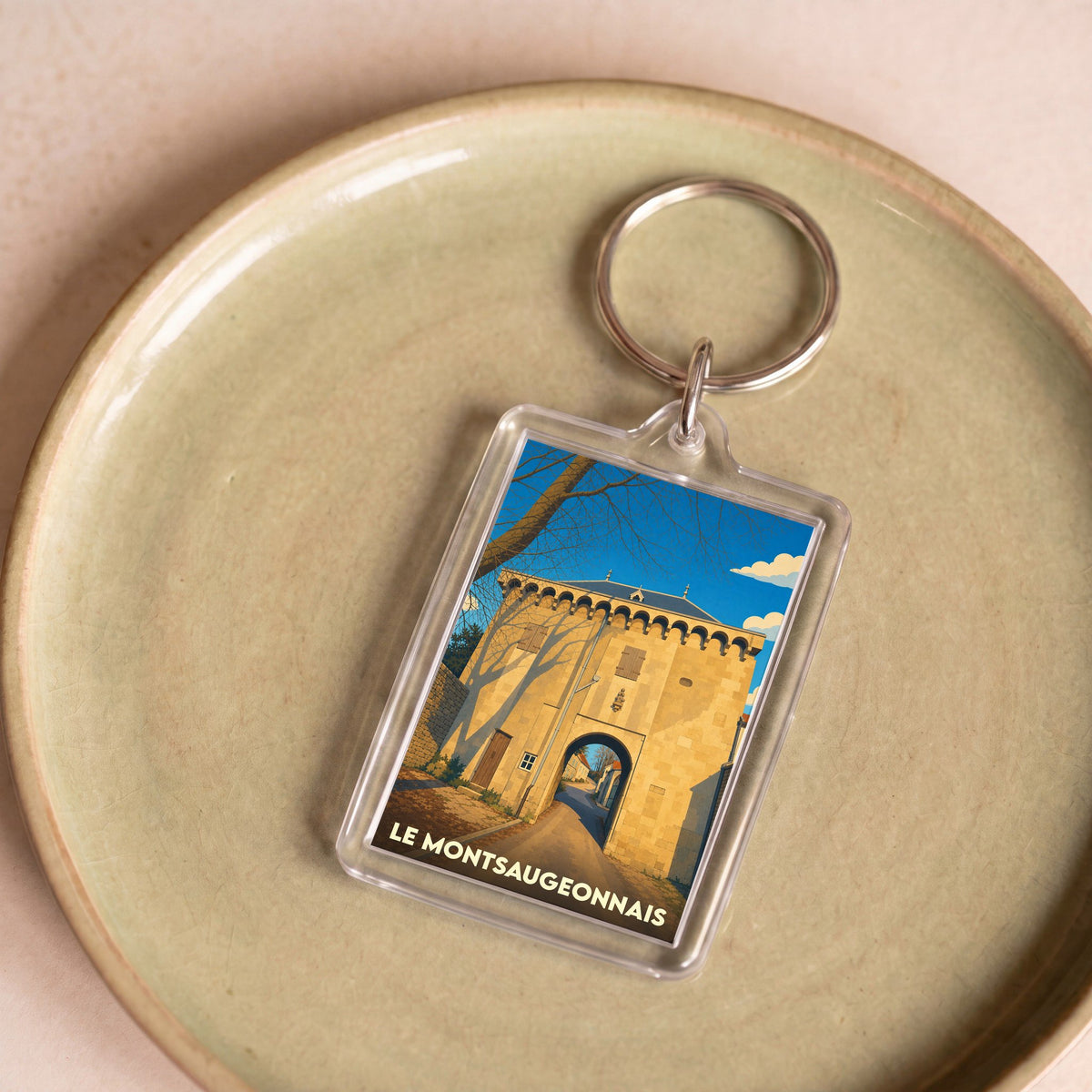 Porte-clés souvenir de la ville de Le Montsaugeonnais avec une illustration stylisée d'une porte historique.