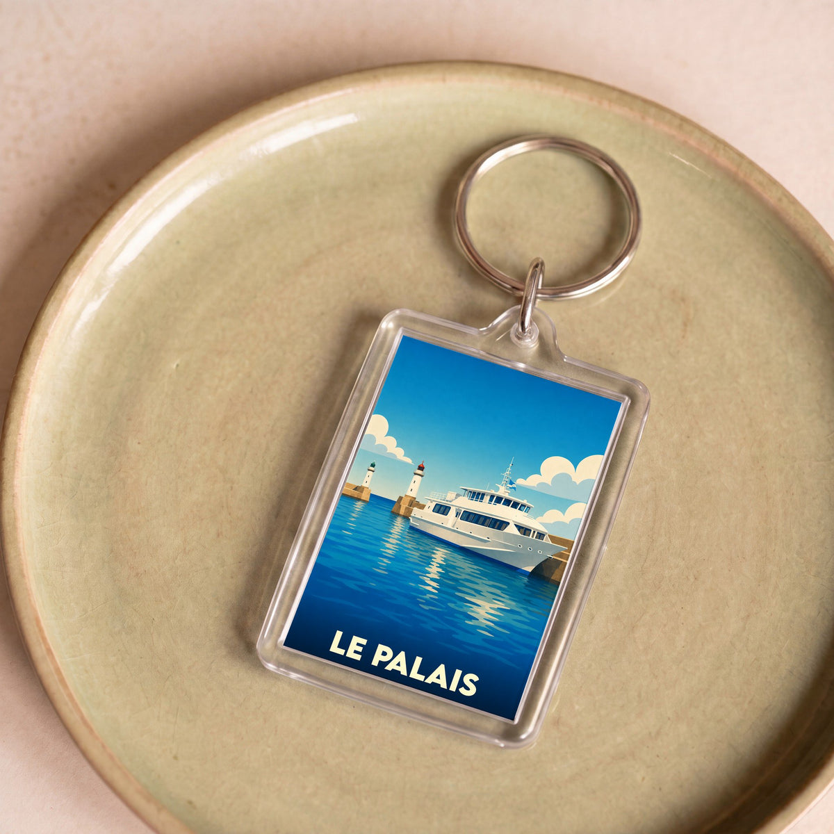 Porte-clés souvenir de la ville de Le Palais avec une illustration stylisée d'un bateau et d'un phare.