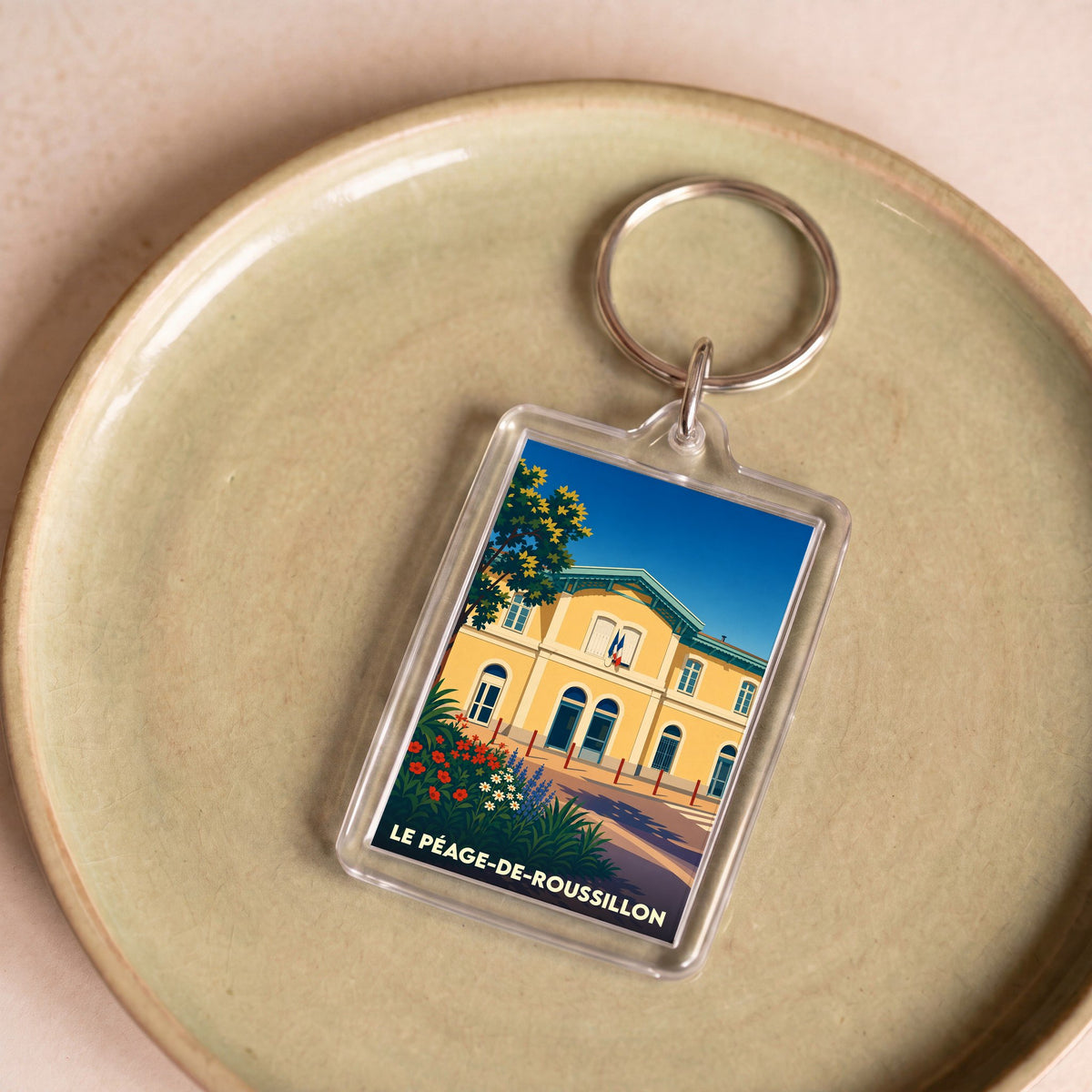 Porte-clés souvenir de la ville du Péage-de-Roussillon avec une illustration stylisée.