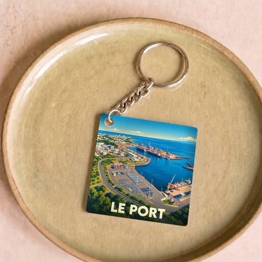 Porte-clés souvenir de la ville de Le Port avec une illustration stylisée vue du ciel.